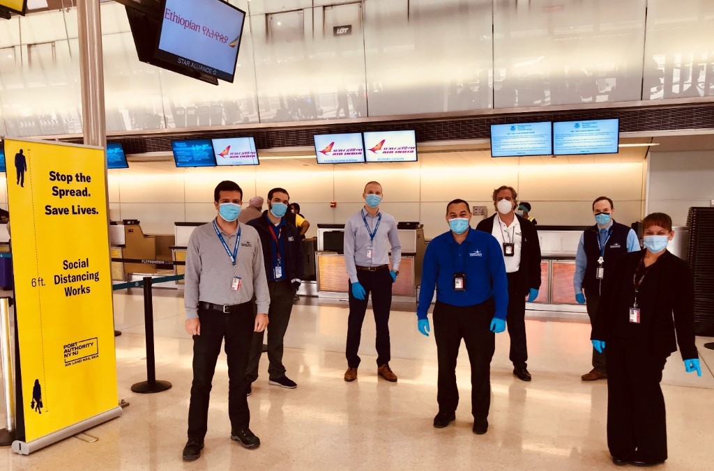 A group of people standing in a room

Description automatically generated